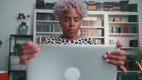 African American Woman Office Worker Closes Laptop and Takes Pose for Meditation