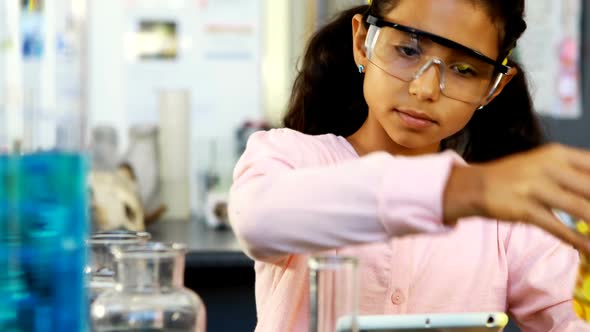 Schoolkid doing using digital tablet while examining chemical 4k