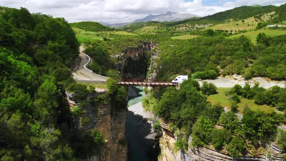 Scenic aerial drone shot of the river flowing in between two rocky cliffs and canyons. With dense lu