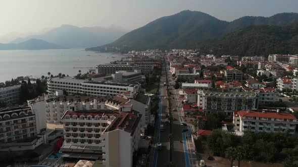 The Camera Flies Over the Roadway in the Resort Town. Along the Road There Are Hotels and Behind