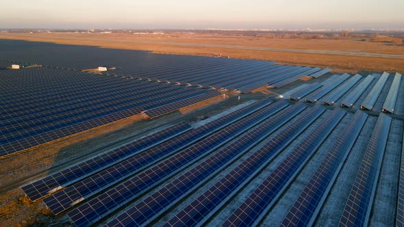 Aerial Drone View of Large Solar Panels at a Solar Farm at Bright Sunset in Early Winter