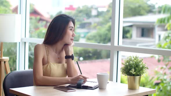 Young beautiful woman using smartphone at coffee shop