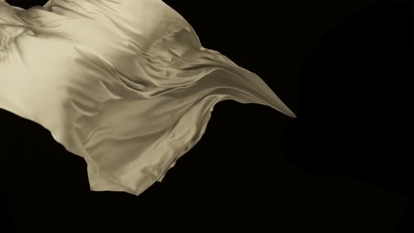 White fabric flowing on black background, Slow Motion