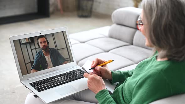 Mature Senior Woman is Using a Laptop for Video Call at Home