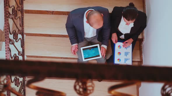 Top View of Businessman Holding Tablet Analysing Graphs