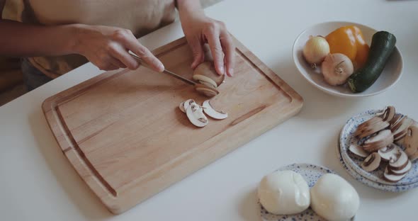 Close-up of woman cutting mushrooms for homemade pizza