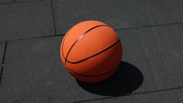 Basketball ball spinning on street paving