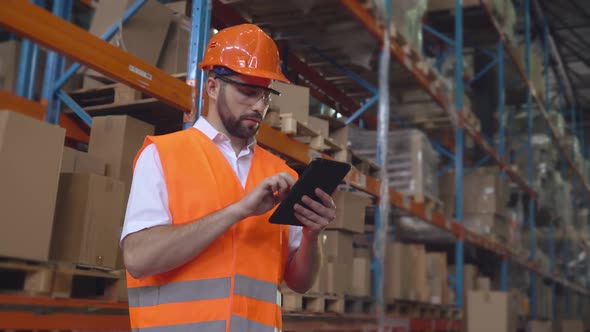 Employee Standing Near Metal Racks with Boxes