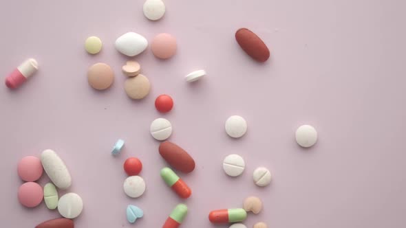 Slow Motion of Many Colorful Pills and Capsules Drops on Table