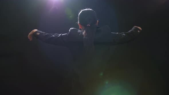 Back View Of Asian Conductor Woman Holding A Baton And Showing Gesture Quickly In The Black Studio