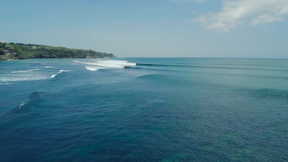 Drone Flight Over Azure Blue Ocean with Barreling Waves on Sunny Day