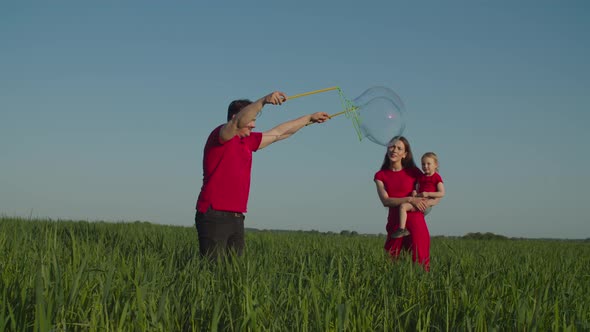 Family with Child Playing with Huge Soap Bubbles