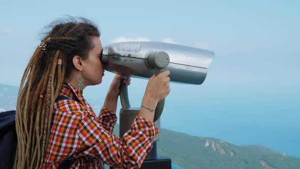 Young Woman Looking Through Street Binoculars