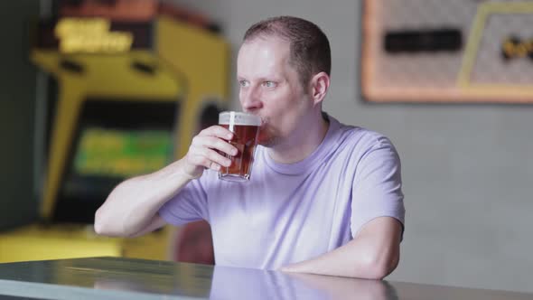 Young Man Drinking Beer a Bar