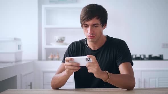 Young Man Playing App Game on a Smartphone Celebrating a Happy Victory in Application Mobile Games