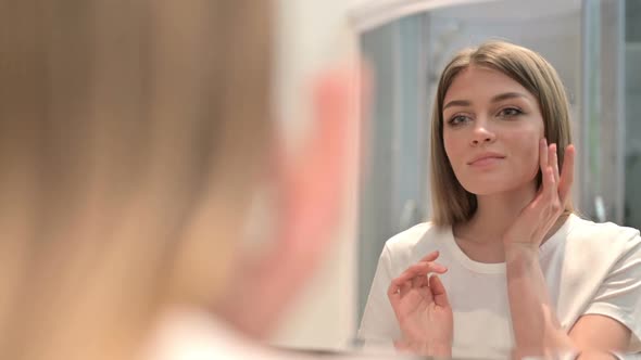 Rear View of Beautiful Woman Doing Face Massage in Mirror