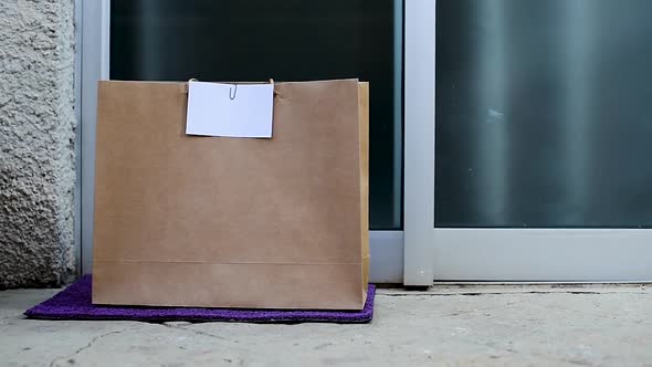 Grocery bag left at the door by delivery boy. Food delivery concept.