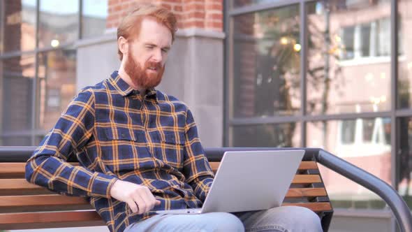 Redhead Beard Young Man with Back Pain Working on Laptop Outdoor