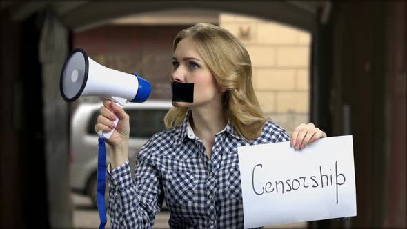 Girl with Taped Mouth Trying to Speak Into Megaphone