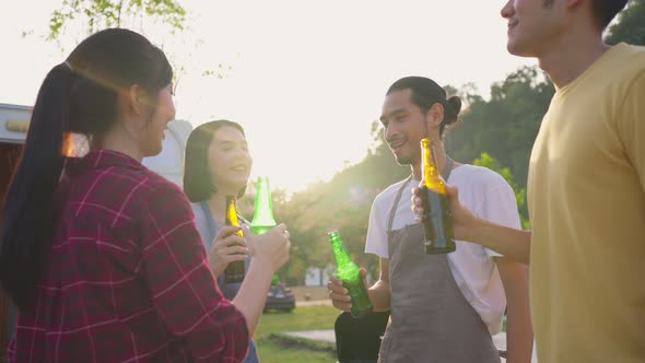 Group of Asian man and woman friend having holiday party outdoor in the evening together in camp.