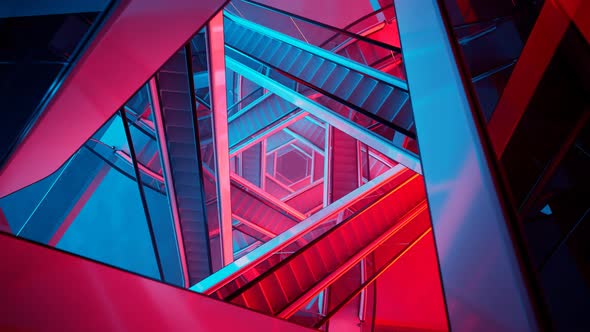 Puzzling labyrinth of escalators made of glass and steel. Blue and red light.