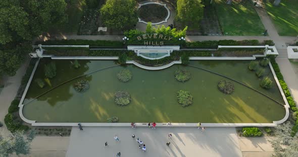 Drone Flying Above Famous Beverly Hills Sign by Fountain on Green Lawn, Garden Landmark in Los Angel