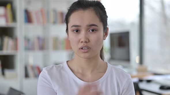 Portrait of Young Asian Woman with Finger on Lips, Quiet Sign 