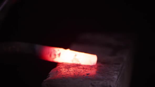 Red hot metal being hammered on anvil