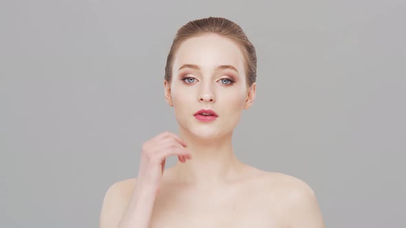 Studio portrait of young, beautiful and natural woman over grey background.