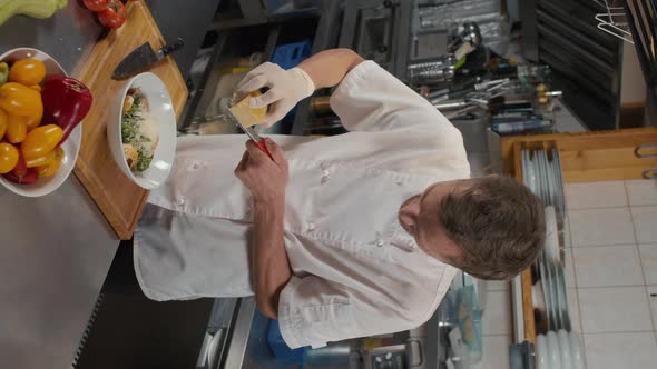 Chef Grating Parmesan Cheese On Salad