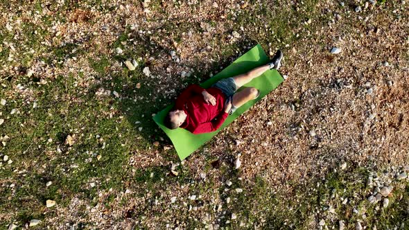 A man rests on a mountain Aerial view 4 K