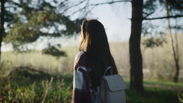 Beautiful Young Hipster Woman in a Shirt Walking Through a Picturesque Pine Forest