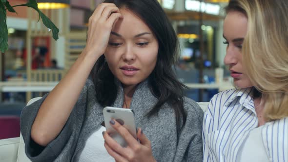 Happy Shopping Asia Woman Use Smartphone with Blond Friend in a Shopping Mall