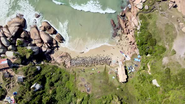 Drone aerial video top of beach with rocks and fisherman houses