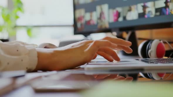 Female graphic designer using laptop in a modern office 4k