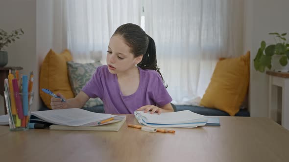 Young girl sitting at home preparing homework for school