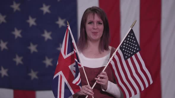 Woman holding up the Union Jack Flag and American Flag