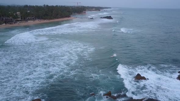 Blue Ocean with White Foaming Waves Against Coastline