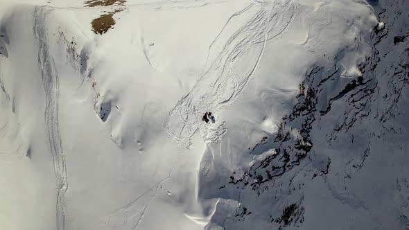 bottom up drone shot of a snowboarder on a snowy mountain top in Switzerland