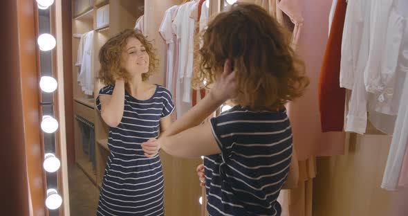 Beautiful Woman Checking Her Hair Looking in Mirror Standing in Closet at Home