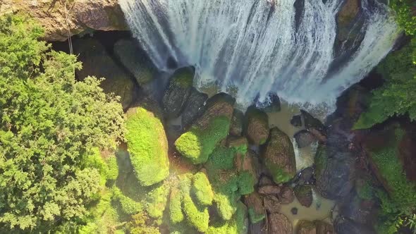 Flycam Moves From Green Boulders Up To Giant Waterfall Top