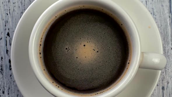 Top Down Slow Motion Shot of Coffee Rotating in a Cup