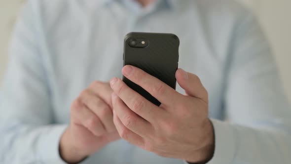 Close Up of Hands of Middle Aged Man Using Smartphone