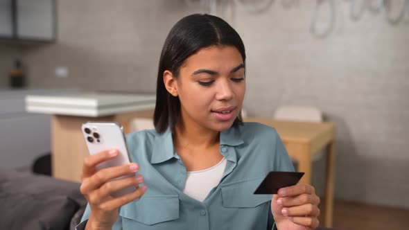 Waist Up Portrait View of the Surprised Pretty Girl Using Her Smartphone and Credit Card