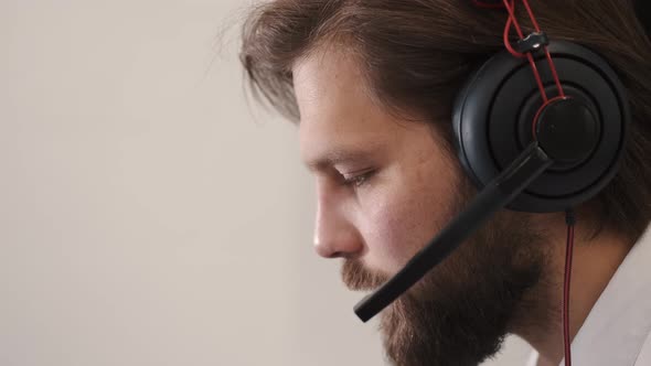 Young Serious Male Call Center Operator Doing His Job with a Headset