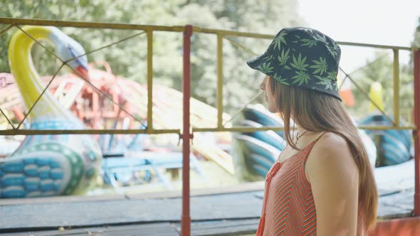 A Girl Looks at a Working Ride in a Children's Park