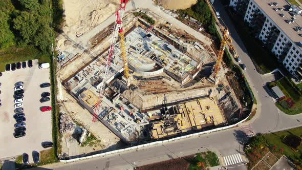 Aerial Flight Over a New Constructions Development Site with High Tower Cranes Building Real Estate.