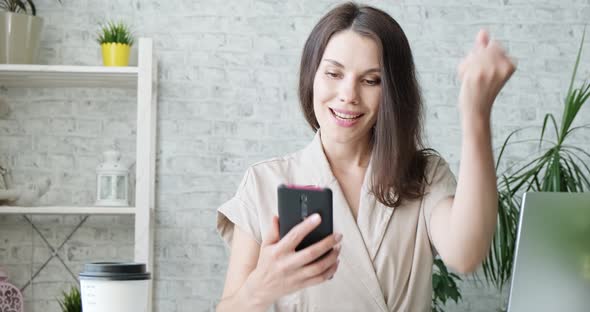 Portrait of Happy Business Woman Enjoy Success on Mobile Phone at Home Office. Closeup Joyful Girl