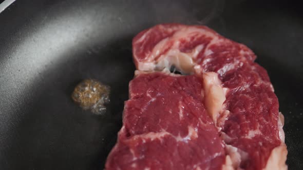 Cooking Rib Eye Steak with Herbs on Grill Pan Close Up Macro Pan Fresh