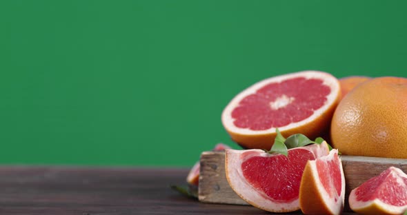 Pieces of Fresh Grapefruit on Wooden Tray Is Slowly Rotating. 